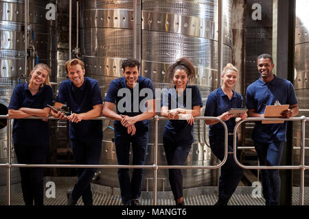 A row of staff at a wine factory smiling to camera, close up Stock Photo