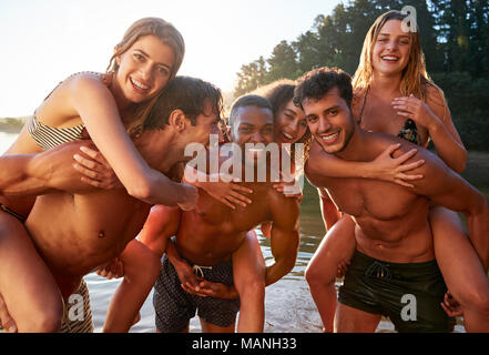 Three young adult couples piggy backing in a lake, close up Stock Photo