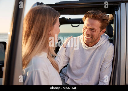 Young couple looking at each other by car, close up Stock Photo