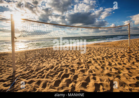 Sunrise over the sea, Volleyball net on the sandy beach. Stock Photo