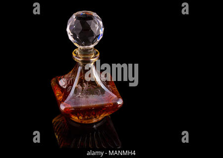 Close Up Shot Of Traditional Luxury Arabic Oud Red Oil Perfume In A Beautiful Handmade Clear Crystal Glass Jar Bottle and Glass Dropper Isolated On Bl Stock Photo