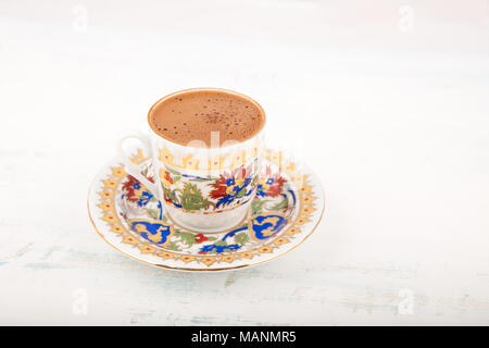 A vintage cup of Turkish black coffee on a saucer placed in the wooden table, with copy space, viewed from high angle Stock Photo