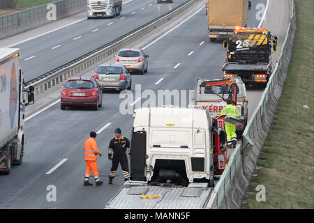 Tow truck workers cleaning wreckage from traffic accident on highway, emergency services response