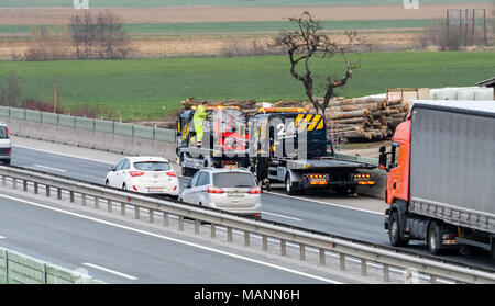 Slovenska Bistrica - March 23, 2018: Tow truck workers cleaning wreckage after traffic accident on highway after a small truck lost control and its tr Stock Photo