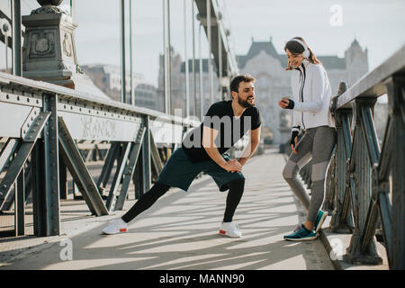 Young handsome couple have training in urban enviroment at sunny day Stock Photo