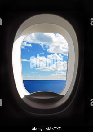 Airplane porthole, view outside an airplane window to blue sky and clouds. Stock Photo