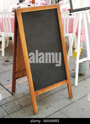 Blank menu signboard at a restaurant. Wooden billboard or chalkboard in front of a restaurant with blank space. Stock Photo