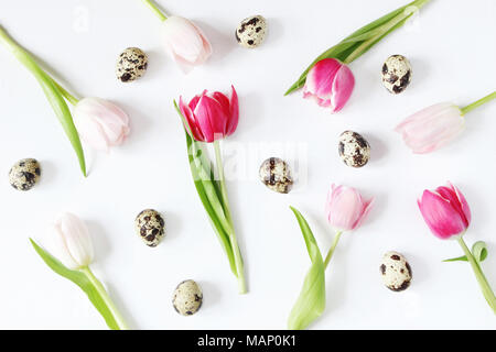 Styled stock photo. Feminine Easter, spring composition with pink tulips flowers quail eggs and on white background. Floral pattern. Flat lay, top vie Stock Photo