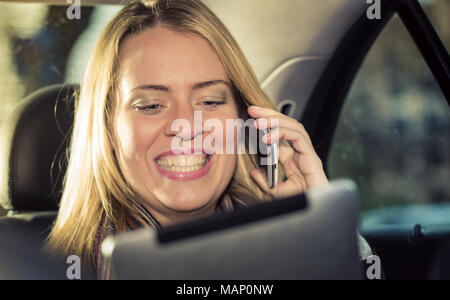 Young businesswoman using tablet computer in taxi Stock Photo