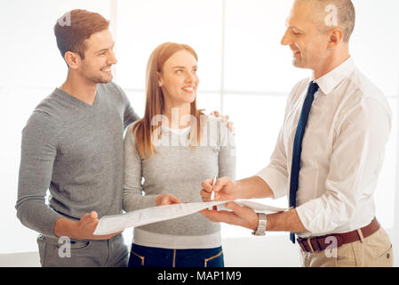 Young couple consult with real estate agent about buying new house. Stock Photo