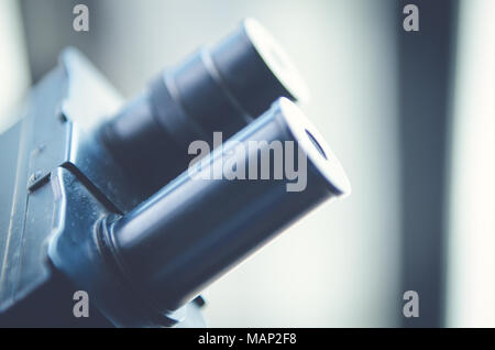 Close-up shot of microscope with metal lens at laboratory. Scientific and healthcare research background. Stock Photo