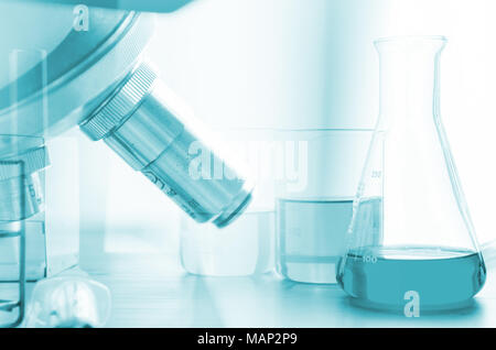 three erlenmeyer flask and microscope , Glassware on  science laboratory research and development Stock Photo