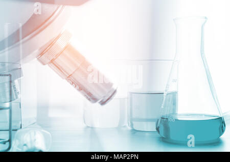 three erlenmeyer flask and microscope , Glassware on  science laboratory research and development Stock Photo