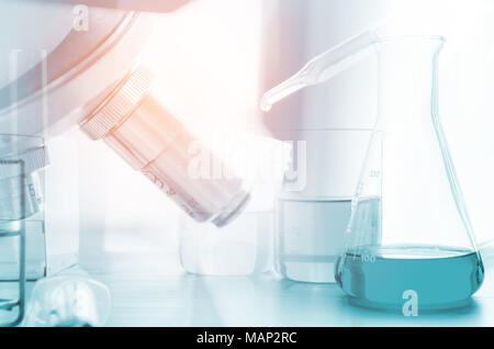 three erlenmeyer flask and microscope , Glassware on  science laboratory research and development Stock Photo