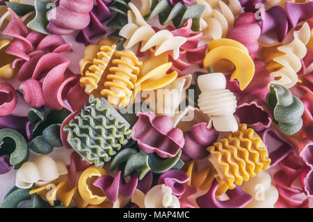 Mixed selection of dried pasta on wooden background. Macaroni scattered on a glass jar. Background. Stock Photo