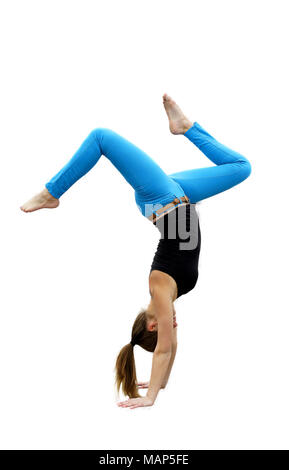 Gymnast doing hand stand isolated on white background. Royal blue pants and black shirt, pony tail swishing ground with legs bent. Stock Photo
