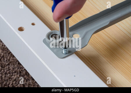 Screwing together flat pack furniture fixings Stock Photo