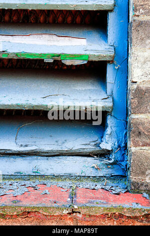 Part of an old wooden ventilation panel in a brick wall Stock Photo