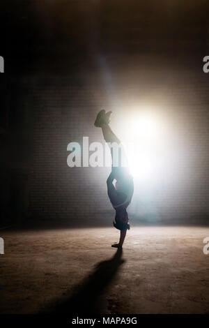male in casual clothers performingextreme break dance movement: revers Stock Photo