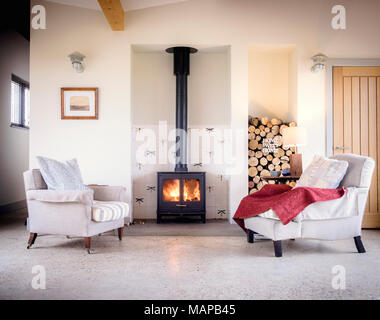 A woodburning stove with two armchairs in a contemporary living room. Stock Photo