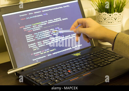 Web developer pointing to PHP code on the screen. Digital technology modern background. Stock Photo