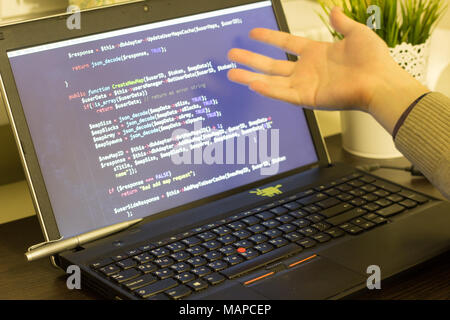 Web developer pointing to PHP code on the screen. Digital technology modern background. Stock Photo