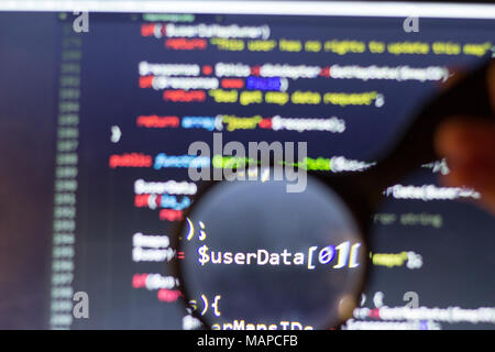 PHP back-end code zoomed through a magnifier. Computer programming source code lookup. Abstract screen of web developer. Stock Photo