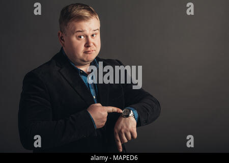 surprised fat caucAsian man who is looking at his watch. Stock Photo