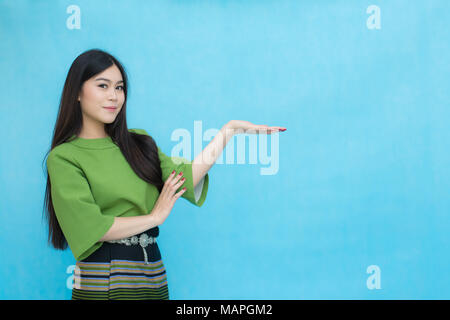 Portrait beautiful Asian girl in traditional Thai dress isolated on blue sky background.  Cotton Dress Stock Photo