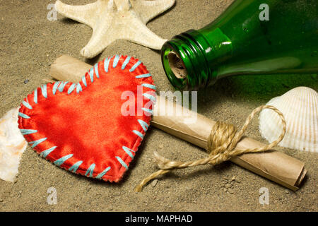 Message and red heart love . A roll of paper in a bottle on the sand. Sea shells. Stock Photo