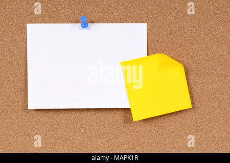 Office index card and sticky note pinned to a cork bulletin board. Stock Photo