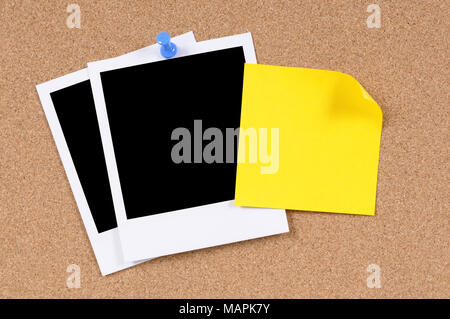 Blank photo prints with sticky note pinned to a cork bulletin board. Stock Photo