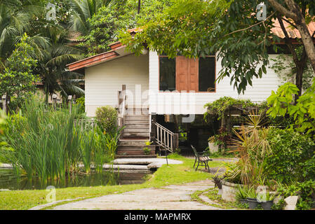 Exterior of Siamese Fighting Fish Gallery in Bang Krachao (Bang Kachao), Bangkok. Thai wooden house surrounded by lush garden vegetation Stock Photo