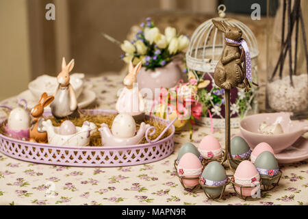 Beautiful Easter pastel decorations with table setting. Porcelain rabbits and Easter eggs. Easter concept and scene Stock Photo