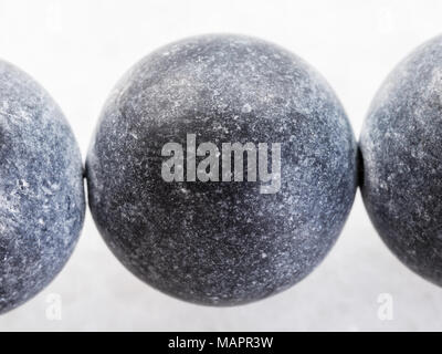 macro shooting of natural mineral rock specimen - necklace from Shungite gemstone on dark granite background Stock Photo