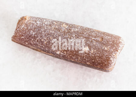 macro shooting of natural mineral rock specimen - thunderstone fossil on white marble background Stock Photo