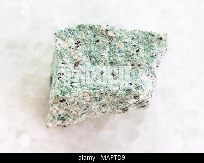 macro shooting of natural mineral rock specimen - raw Trachyte stone on white marble background Stock Photo
