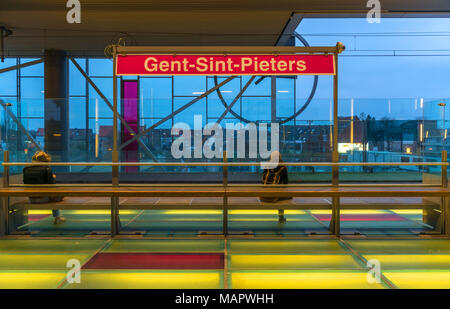 Two persons waiting on a platform of the Gent train station with illuminated floor and flashy colors, Belgium. Stock Photo