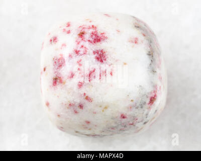 macro shooting of natural mineral rock specimen - cinnabar in polished white dolomite stone on white marble background from Peru Stock Photo