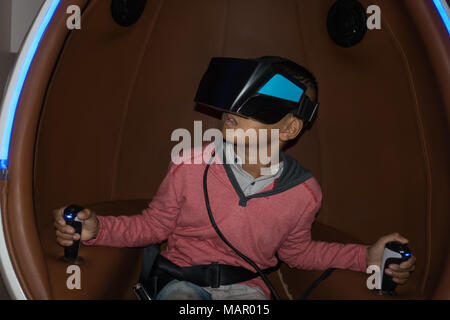 Young beautiful Asian boy wearing a virtual reality game Stock Photo