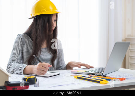 Architect or planner working on drawings for construction plans at a table Stock Photo