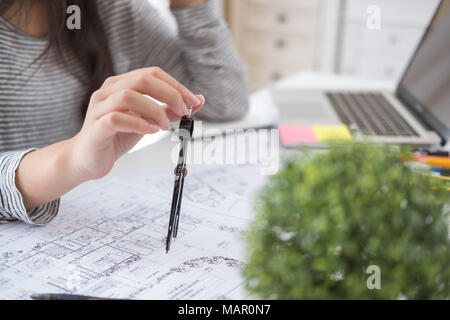 Architect or planner working on drawings for construction plans at a table Stock Photo