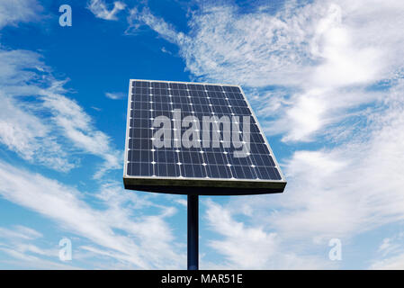Small Solar Panel Against a Cloudy Blue Sky Stock Photo