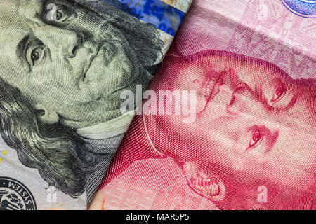 Close up of one hundred Dollar and 100 Yaun banknotes with focus on portraits of Benjamin Franklin and Mao Tse-tung/USA vs China trade war concept Stock Photo