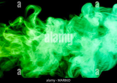 Dense green multicolored smoke on a black isolated background. Background of smoke vape Stock Photo