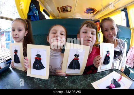 Teen girls sitting in the streetcar cabin and showing their handmade work - applique papers.March 26, 2018. Kiev, Ukraine Stock Photo