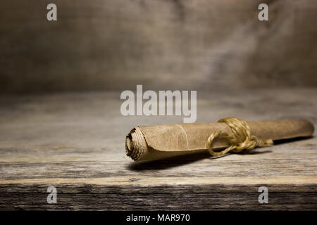 Paper scroll on the wooden table. Stock Photo