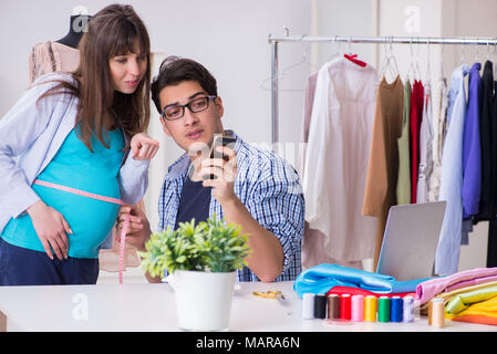 Pregnant woman visiting tailor for new clothing Stock Photo