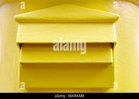 Classic yellow mail box detail. Postbox. Postal service. Traditional communication Stock Photo