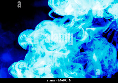 Dense blue smoke on a black isolated background. Background of smoke vape Stock Photo